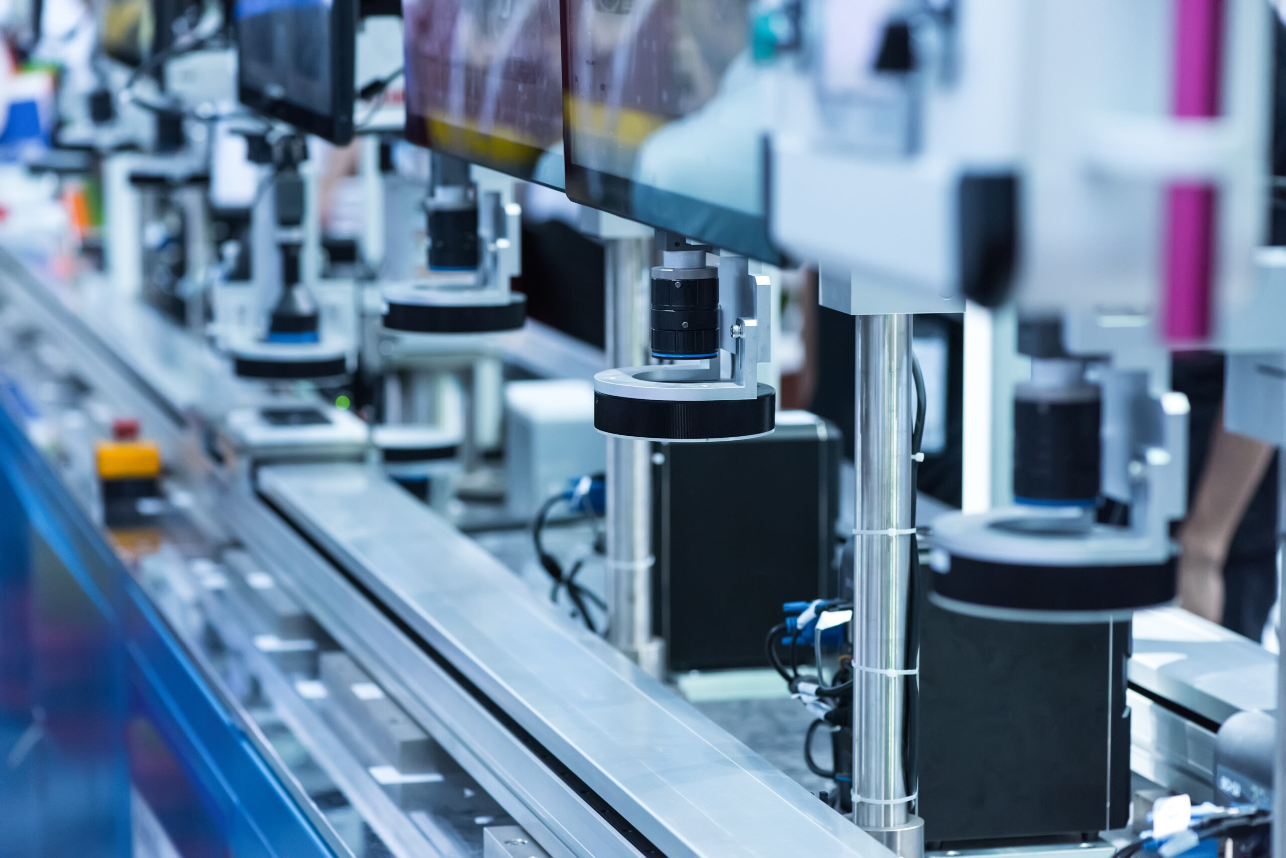 Automated machinery with cameras and sensors aligned on a conveyor system, illustrating advanced technology in a manufacturing setup.